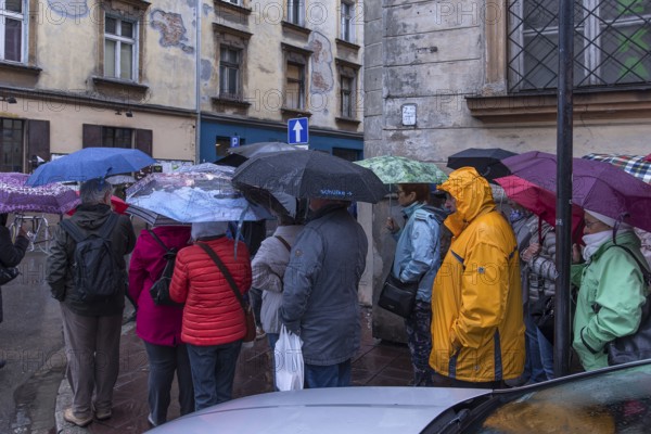 Travel group in the rain in front of the hotel, Krakow, Poland