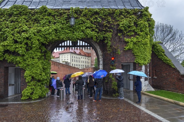 Tourists with umbrellas on Wavel Hill, Krakow, Poland