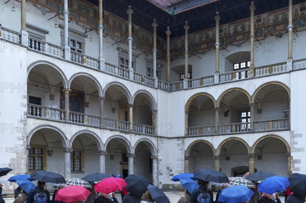 Arcades of the north and east wings of Wavelschloss, in front visitors with umbrellas, Wavelhügel, Krakow, Poland