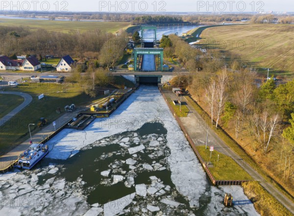 A frozen water surface in front of a lock, with gardens and trees on the edge, aerial view, Niegripper connection channel, connection between Elbe and Elbe-Havel Canal, Jerichower Land, Saxony-Anhalt, Germany
