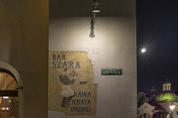Advertisement for a bar on a house wall, Krakow, Poland