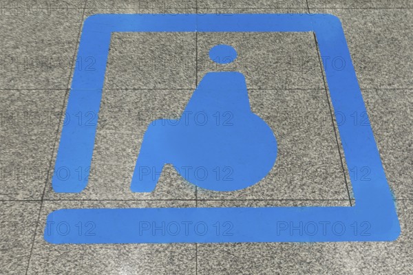 Sign for disabled people in front of a baggage carousel at the airport, Krakow, Poland
