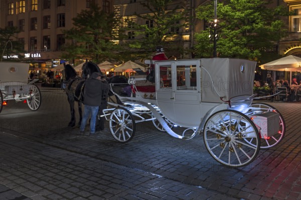 Waiting horse-drawn carriages at the market square at night, Krakow, Poland