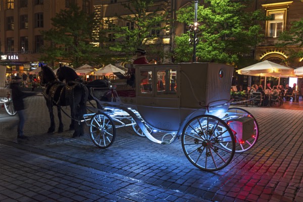 Waiting horse-drawn carriage at the market square at night, Krakow, Poland