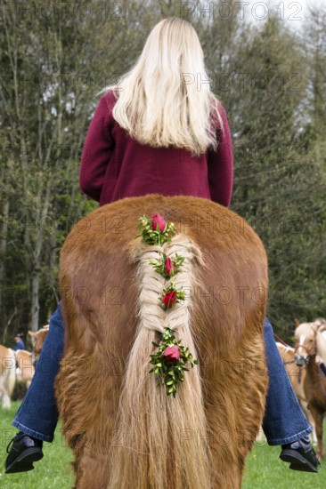 Blonde girl riding decorated horse, traditional Georgian ride at the Penzberg Hubkapelle, Upper Bavaria, Germany