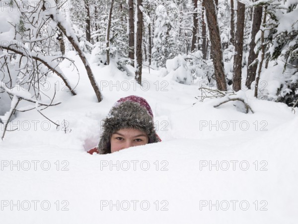 Girl, 14 years old, sunk in deep snow, in snowy pine forest, deep snow, winter, funny, humor, Upper Bavaria, Germany