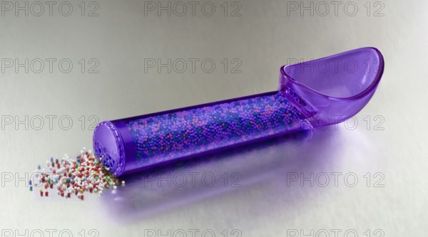 Purple, transparent ice cream scoop filled with colored sugar sprinkles