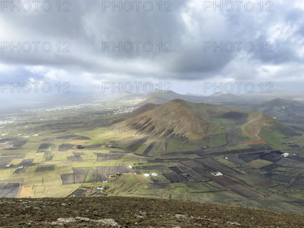 View of Montaña Tesa volcano from Montaña Blanca mountain with cloudy sky, Lanzarote, Canary Islands, Spain