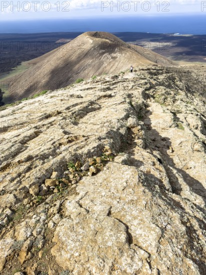 View from Caldera Blanca volcano against blue sky with white clouds, Mancha Blanca, Lanzarote, Canary Islands, Spain
