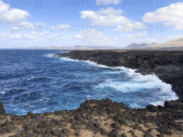 Wave-covered rocky coast with lava rocks near Punta Piedra Alta, Lanzarote, Canary Islands, Spain