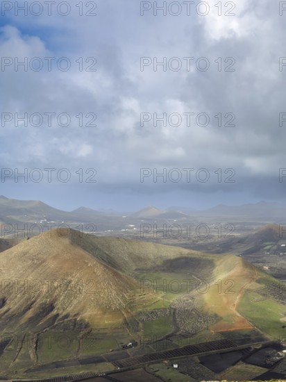 View of Montaña Tesa volcano from Montaña Blanca mountain with cloudy sky, Lanzarote, Canary Islands, Spain