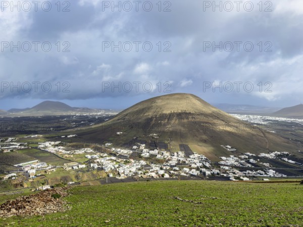 View from Montaña Blanca mountain to the town of Montaña Blanca with cloudy sky in the background, Lanzarote, Canary Islands, Spain