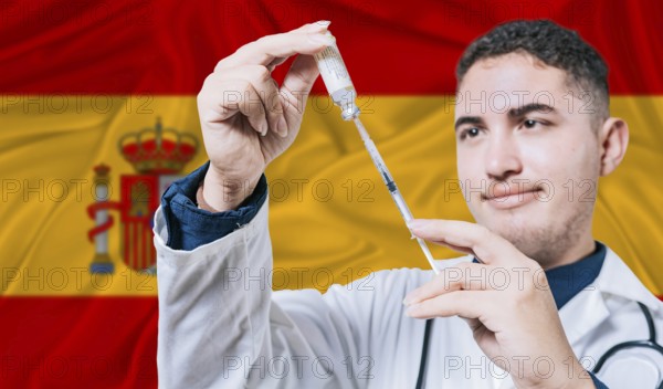 Doctor holding syringe on Spain flag background. Medical professional holding syringe with Spanish flag in the background