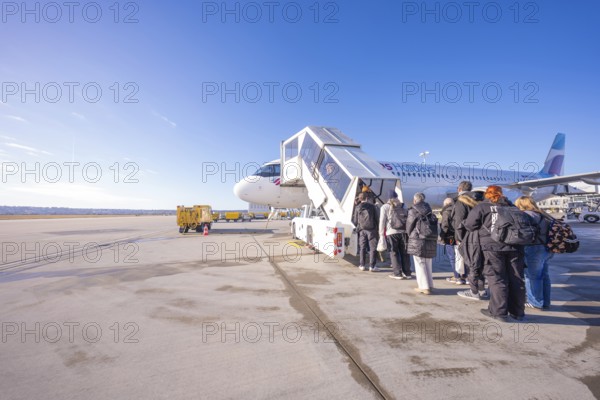 Passengers board a Eurowings aircraft under clear skies, Stuttgart Airport, Germany