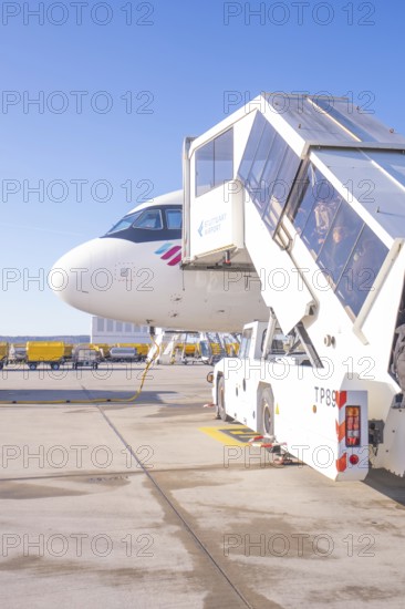 Close-up of an airplane with mobile stairs in the sunshine on the airport apron, Stuttgart Airport, Germany
