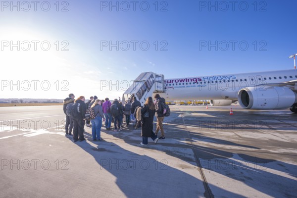 Group of travelers boards Eurowings aircraft in sunny weather, Stuttgart Airport, Germany