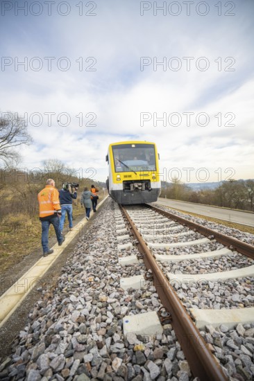 A train on rails with photographers in orange vests in a natural environment, acceptance of the Hermann Hessebahn, Calw, Germany