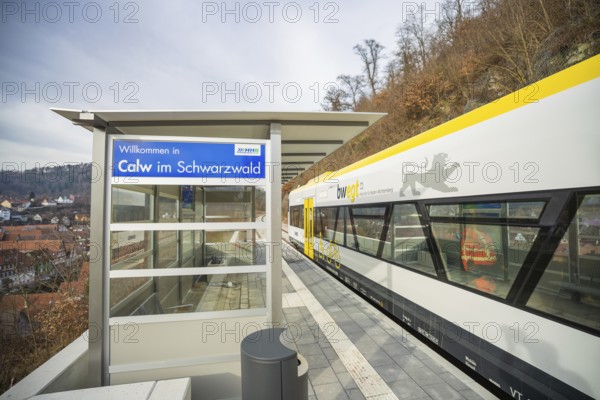 A modern train station in Calw with an outbound train surrounded by wooded hills, taking the Hermann Hessebahn, Calw, Germany