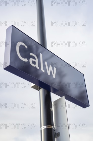A simple town sign with the name Calw in the open air next to a street lamp, taking off the Hermann Hessebahn, Calw, Germany