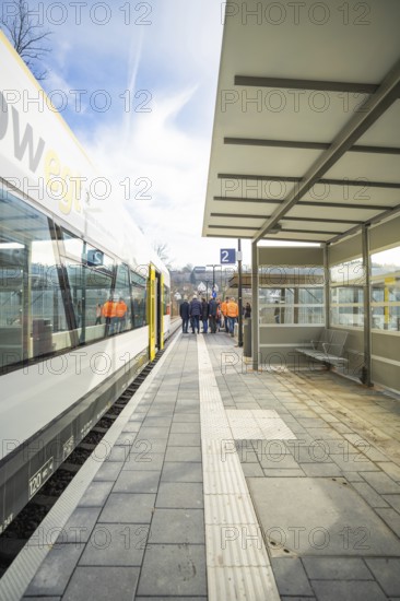A sunny station area with people on a platform next to a waiting train, acceptance of the Hermann Hessebahn, Calw, Germany