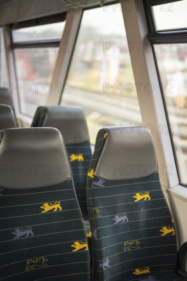 Two train seats with blue fabric and yellow lion patterns next to train windows in the interior, acceptance of the Hermann Hessebahn, Calw, Germany