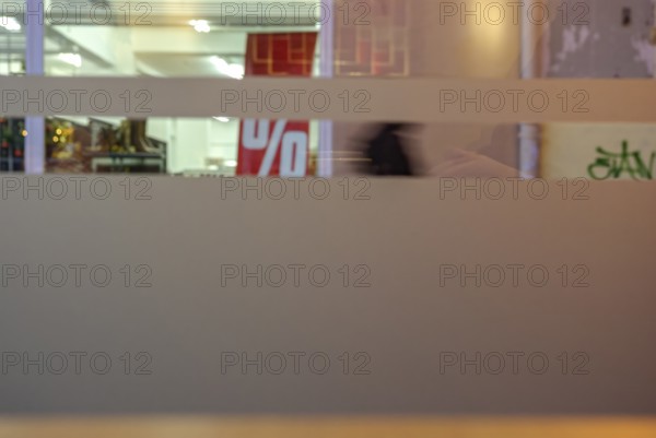 Symbolic picture of final sale: A percentage sign visible through the shop windows of a retail store indicates the sale, sale or general discount campaign