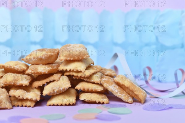 Rhenish pastries called 'Mutzen pastries or Muzenblätter' with powdered sugar on festive background. Traditional German carnival and Fasching fried pastry