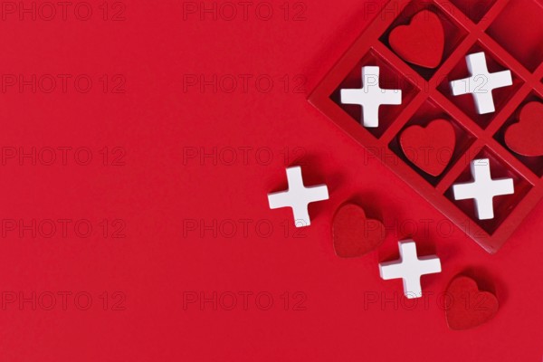 Valentine-themed heart game with red hearts and white Xs in a red box on a red background with copy space