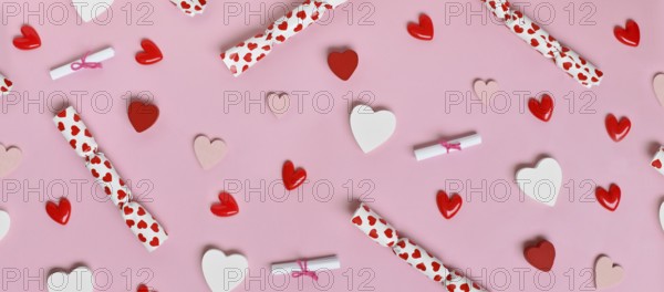 Cute Valentine's Day banner with pink, white and red hearts and small gift bags on a pastel pink background