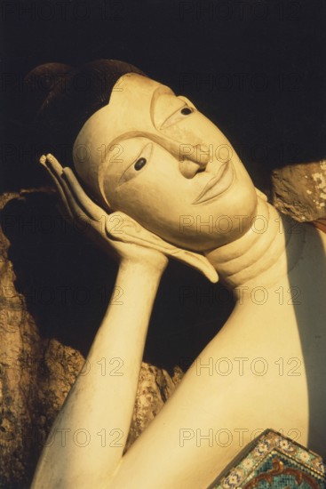 Reclining alabaster Buddha at Wat Sai Thai. The reclining Buddha symbolizes the last earthly hours in front of entering Nirvana. This state is called Paranirvana, a state reserved only for enlightened beings at the end of their lives. Buddhism, religion, Krabi, southern Thailand, Thailand, Southeast Asia