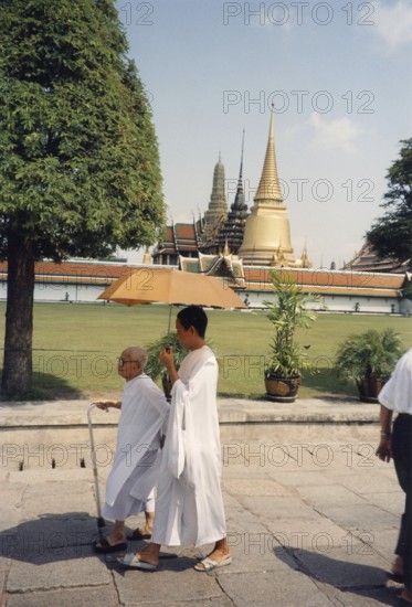 Bhikkhuni, Buddhist nuns walking with parasol in front of Wat Phra Kaeo, (Temple of the Emerald Buddha, official name Wat Phra Sri Rattana Satsadaram) Buddha, Buddhism, Religion, Bangkok, Thailand, Southeast Asia