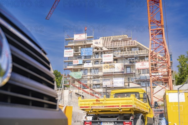 Construction site with crane and yellow construction vehicle in front of a building under construction, carpentry, new building, Stuttgart, Germany