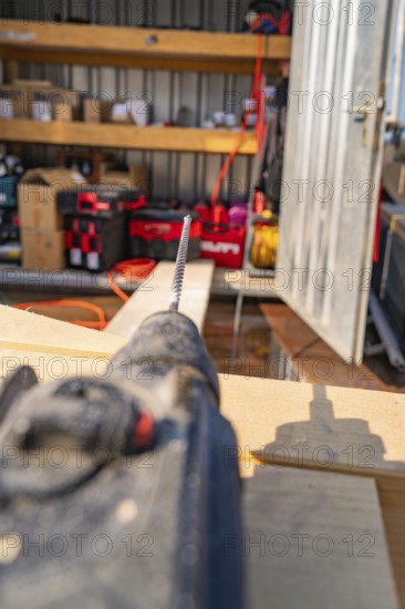 Close-up of a drill in a workshop environment with shelves and order, carpentry, new building, Stuttgart, Germany