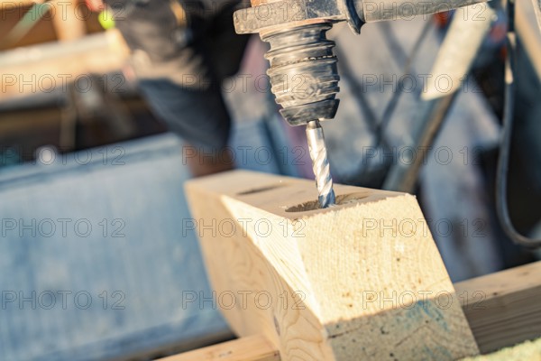 Detailed view of a drill drilling a hole in wood on a construction site, carpentry, new building, Stuttgart, Germany