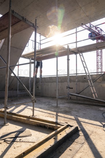 Construction site scene with scaffolding and sunlight, construction worker working on construction, carpentry, new building, Stuttgart, Germany