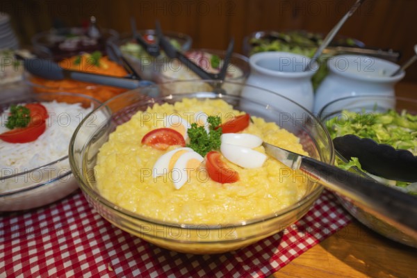 Buffet menu with potato salad and various side dishes served in bowls
