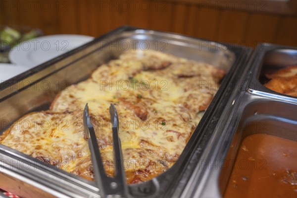 A meat dish with melted cheese in a metal mold