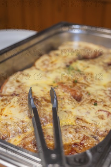 A meat dish with melted cheese in a metal mold