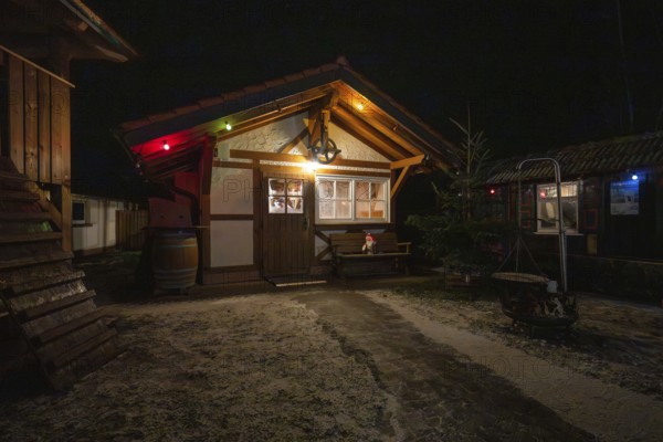 Illuminated wooden hut at night with Christmas decoration in a winter scene