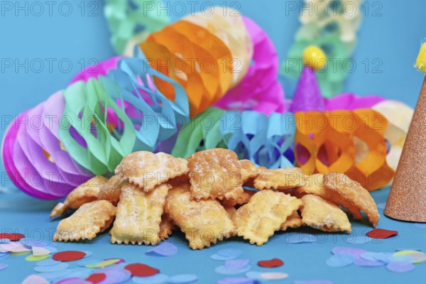 Rhenish pastries called 'Mutzen pastries or Muzenblätter' with powdered sugar on festive background. Traditional German carnival and Fasching fried pastry