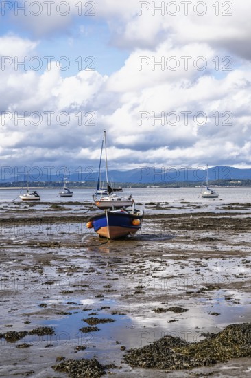 Boats on mud of Forth Estuary over Blackness Castle, Blackness, Scotland, UK