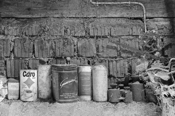 Old weights and cans for storing screws etc. in a hayloft, on a former Franconian farm, black and white, Bavaria, Germany