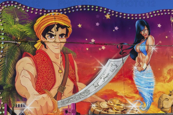 Painted illustration of Aladin brandishing a sword and a voluptuous blue eyed genie on amusement ride at Fun Show traveling amusement ride park, Old Port of Montreal, Quebec, Canada
