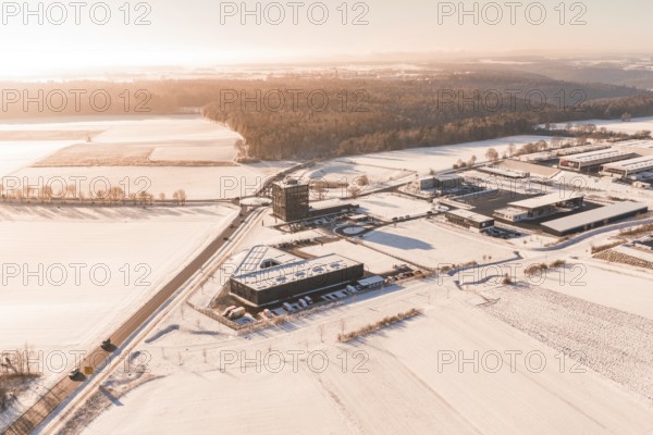 Snowy field, industrial area on the horizon under morning light, Nagold, Calw district, Black Forest, Germany