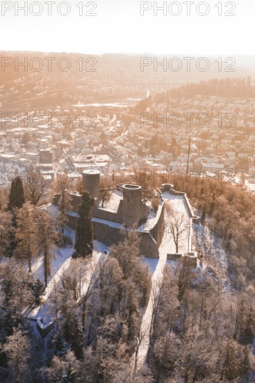 Castle on a wooded hill surrounded by a snowy urban landscape, Nagold, Calw district, Black Forest, Germany