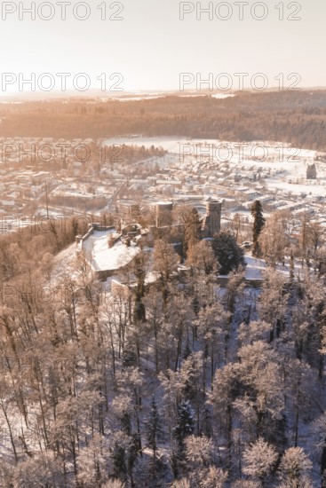 Snow-covered castle on a hill with forest and city in the background, Nagold, Calw district, Black Forest, Germany