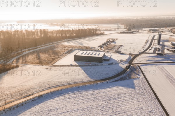 Snow-covered industrial plants and fields under clear sky at sunrise, Nagold, Calw district, Black Forest, Germany
