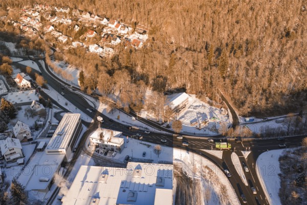 Aerial view of a snowy village surrounded by forest and roads in a wintry atmosphere, Nagold, Calw district, Black Forest, Germany