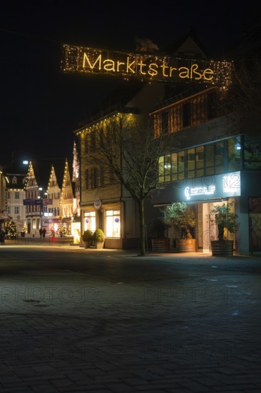 Festively illuminated city street at night with decorated entrance and historic buildings, Nagold, Calw district, Black Forest, Germany