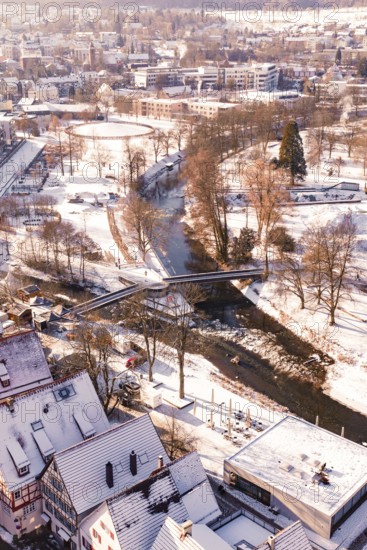 Wintery cityscape with river and bridge, houses and roads covered by snow, Nagold, Calw district, Black Forest, Germany